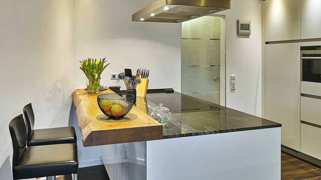 Hoekkeuken in hoogglans wit met schiereiland en houten bar van Contur - Ekelhoff Keukens in Nordhorn