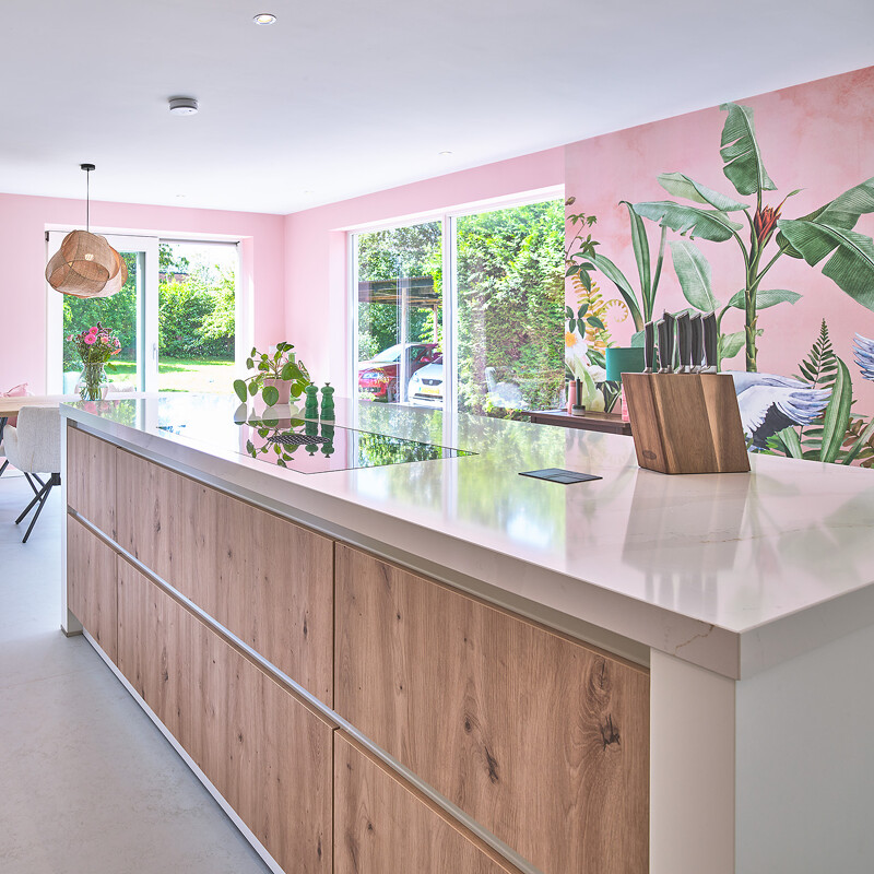 Eilandkeuken in eiken met wit composiet keukenblad en witte zijpanelen en ombouw. Gerealiseerd in Groningen door Ekelhoff keukens in Nordhorn