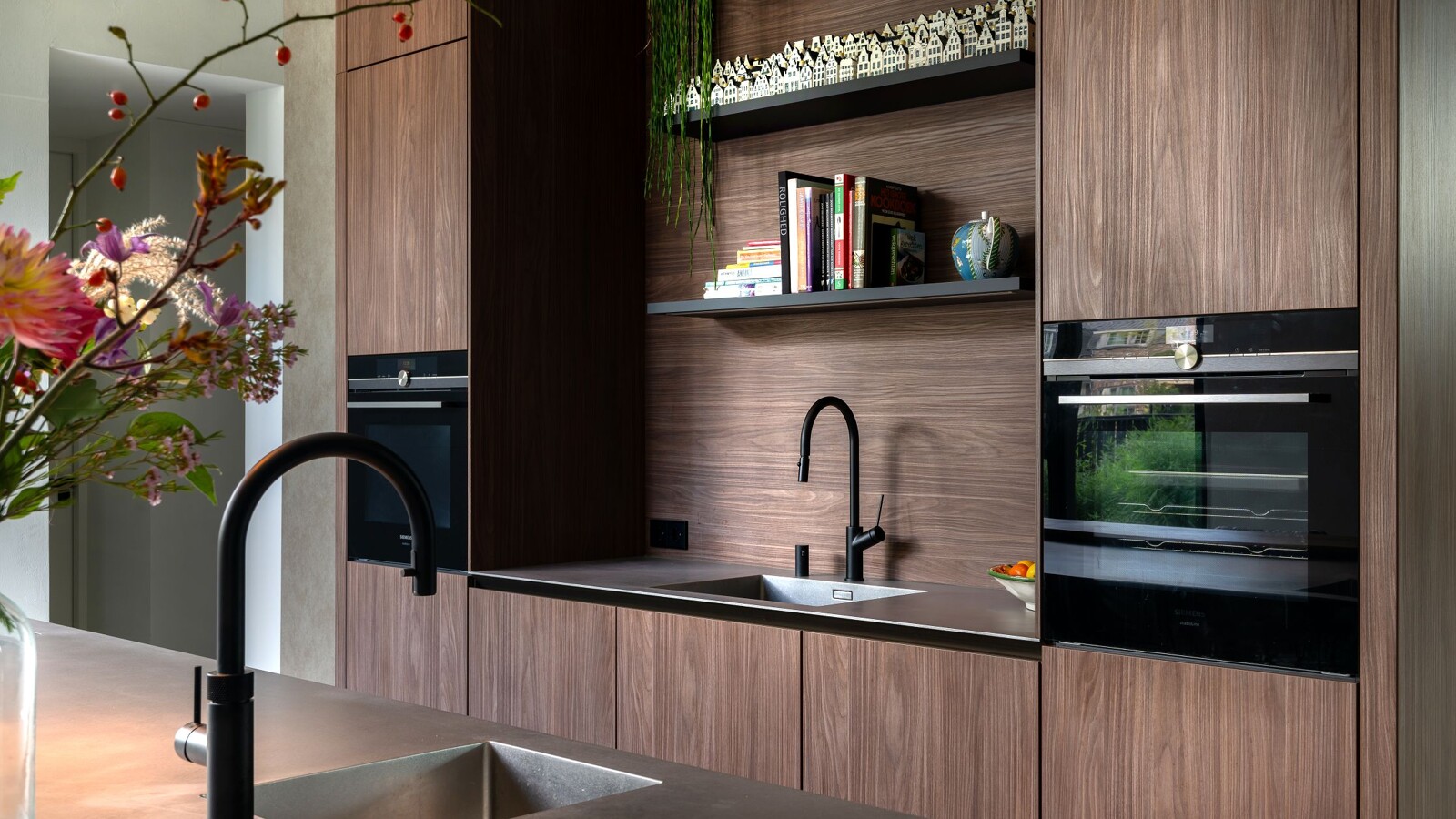 Ontdek deze prachtige SieMatic SLX Pure eilandkeuken in Walnut Lincoln met twee rvs keukenbladen en Quooker. Gerealiseerd in Laren door Ekelhoff Keukens, Nordhorn.