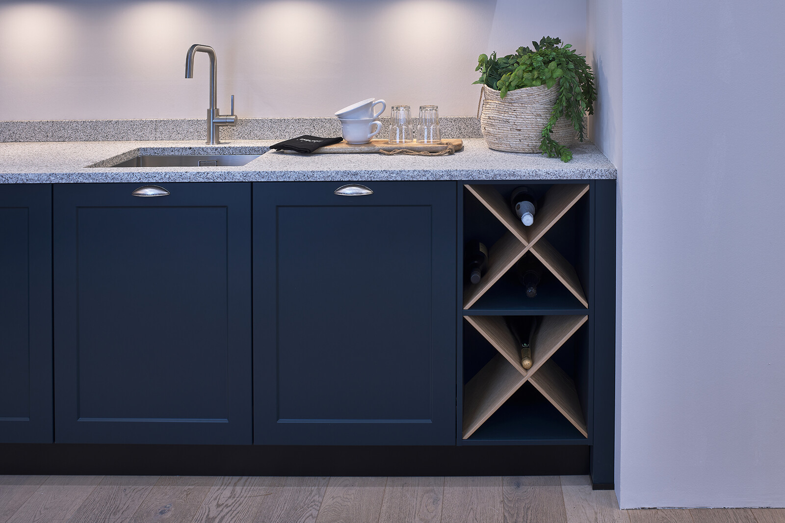 Showroomkeuken: Donkerblauwe landelijke hoekkeuken met wit granieten blad en houten details