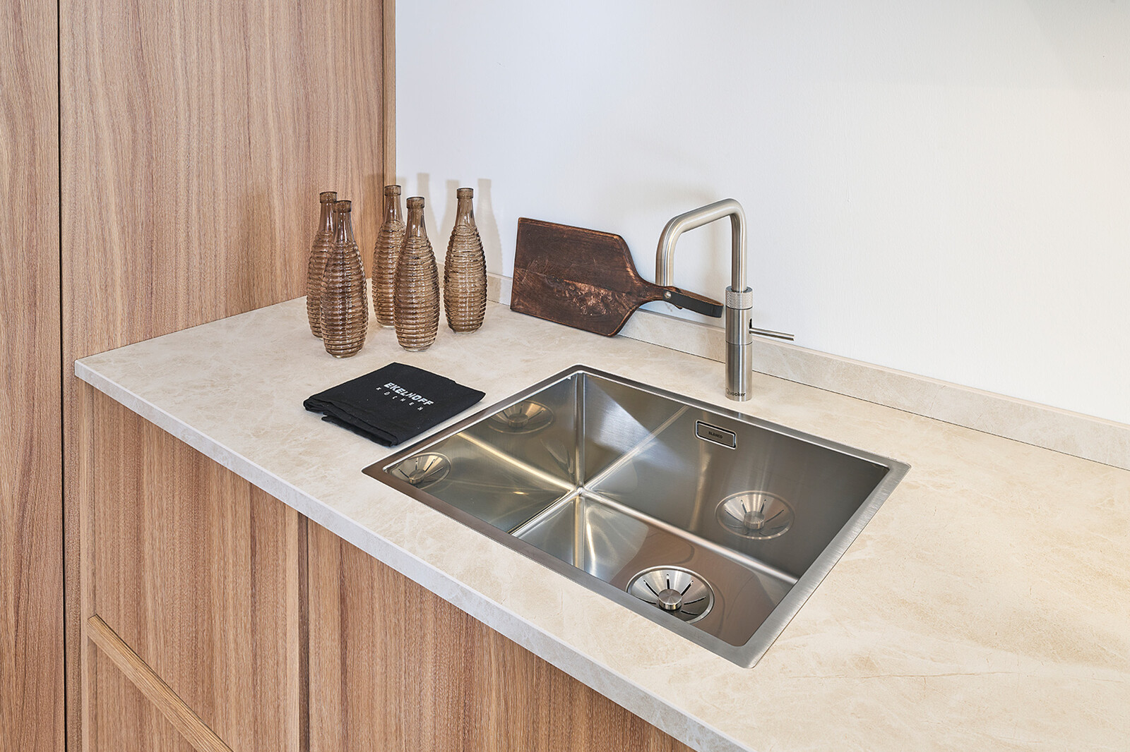Showroomkeuken: Maatwerk Japandi keuken in licht eikenfineer met keramiek blad en rvs Quooker Square en spoelbak