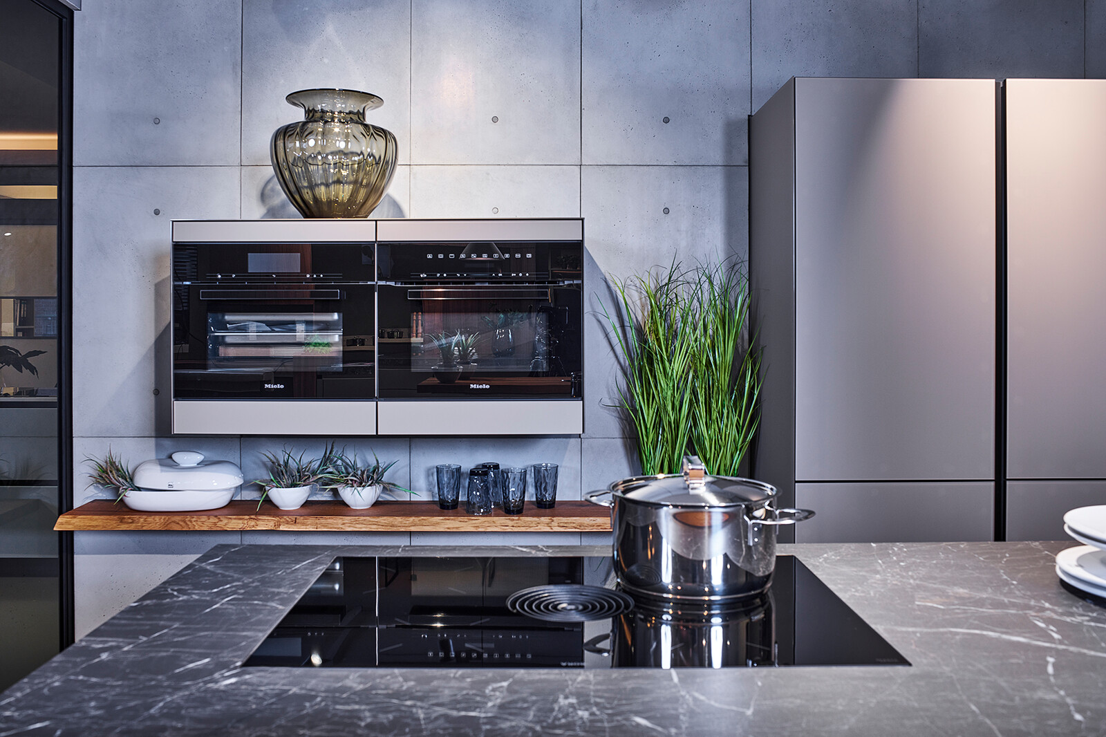 Showroomkeuken: next125 compacte industriële eilandkeuken met matglas fronten, bora kookplaat en gaggenau ovens