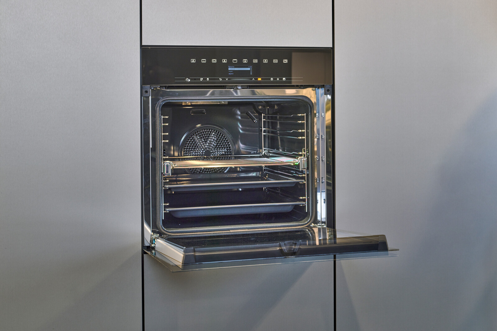 Showroomkeuken: next125 designkeuken in SensiQ met groen graniet blad en Siemens combi oven