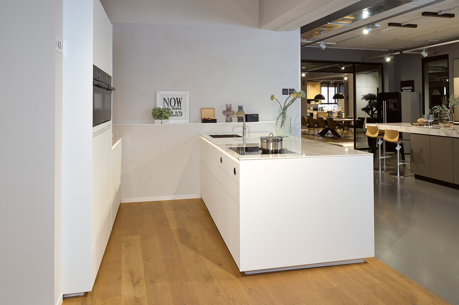 Showroomkeuken next125 - Witte eilandkeuken in fenix met notenhout en keramiek keukenblad