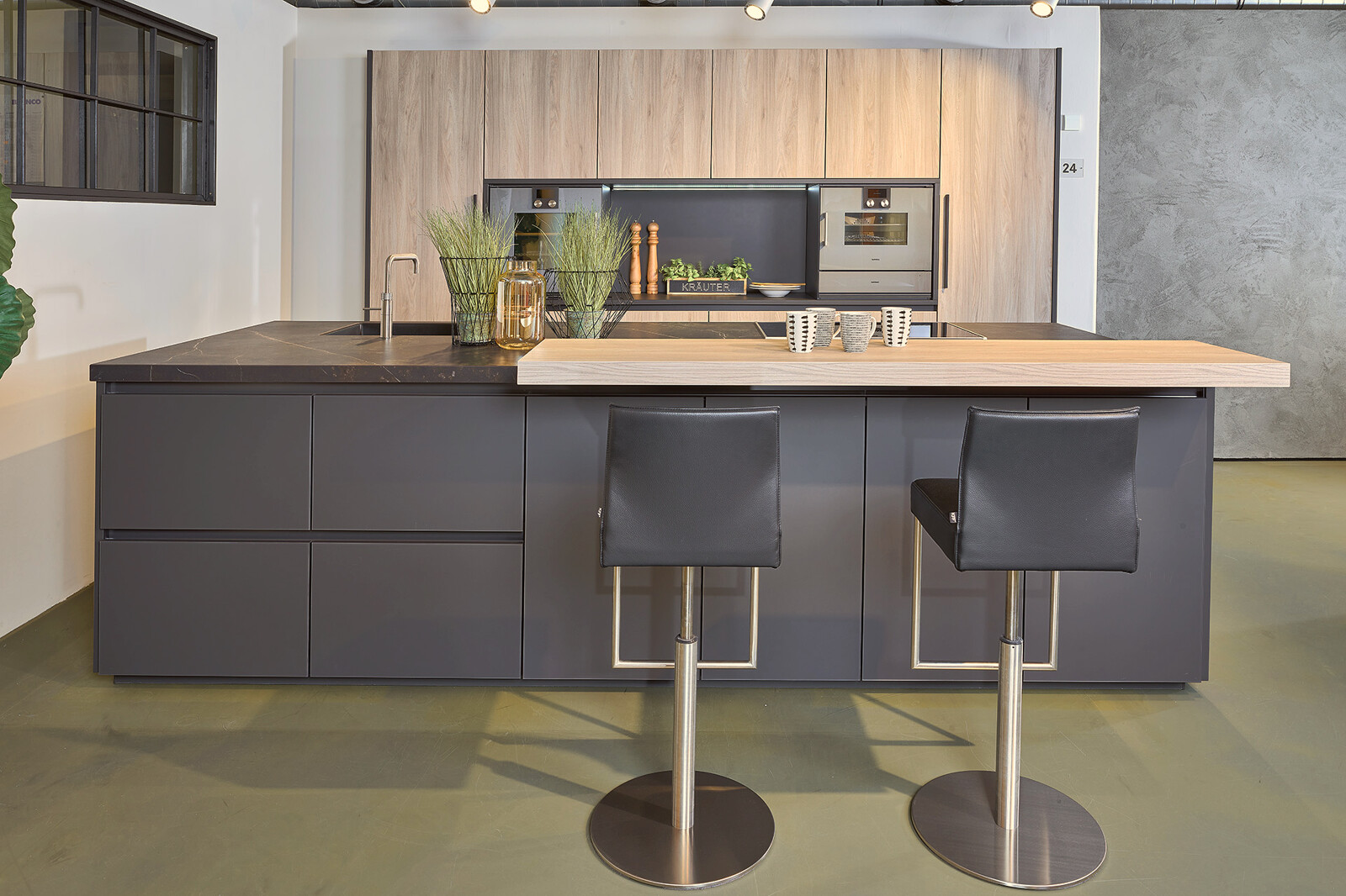 Showroomkeuken: Zwarte eilandkeuken met hout en Dekton blad