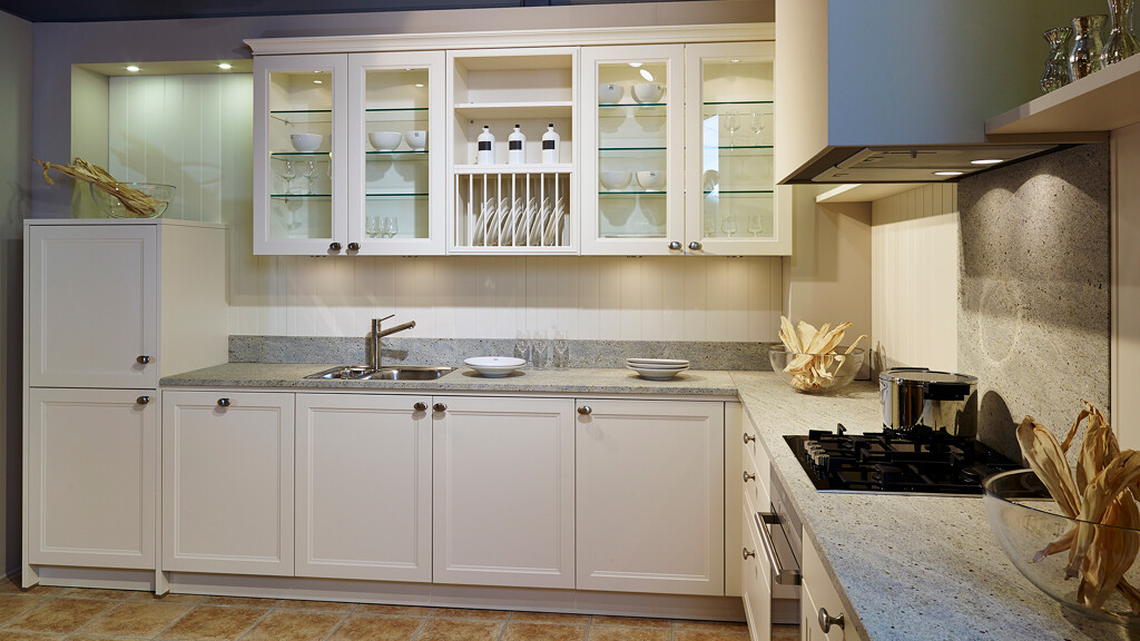 Landelijke hoekkeuken in gebroken wit met vitrine bovenkastjes van Contur, met een granieten werkblad. Ontdek Ekelhoff Kuchen in Nordhorn.