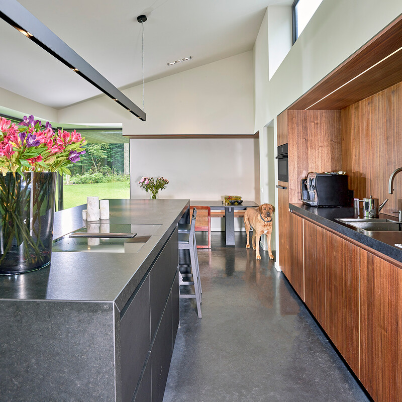 Maatwerkkeuken kookeiland - eilandkeuken in onyxzwart fenix met een achterwand en een nis in notenhout