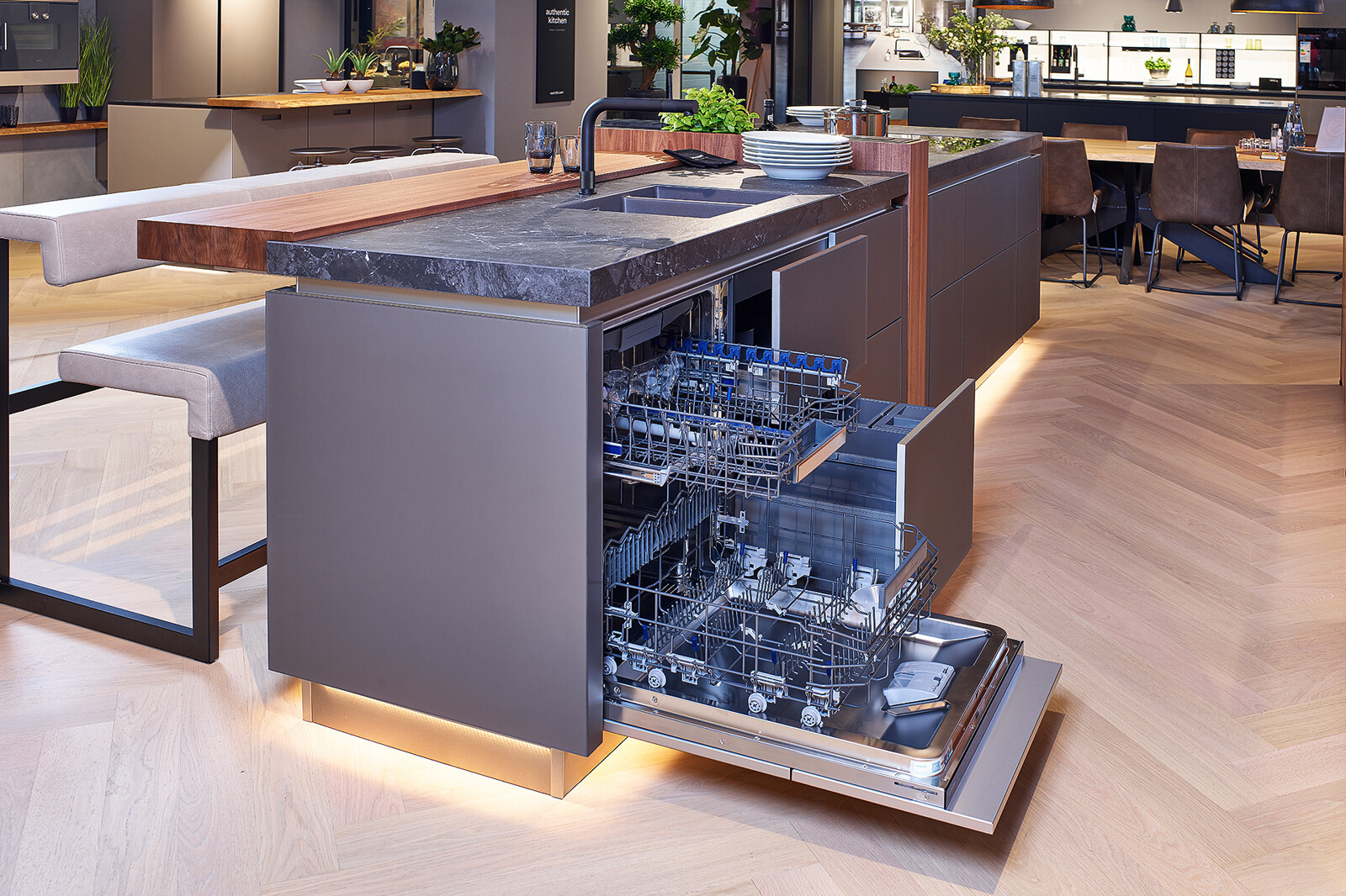 Showroomkeuken: next125 design eilandkeuken met ribbelfronten in notenhout en matglas met Siemens apparaten
