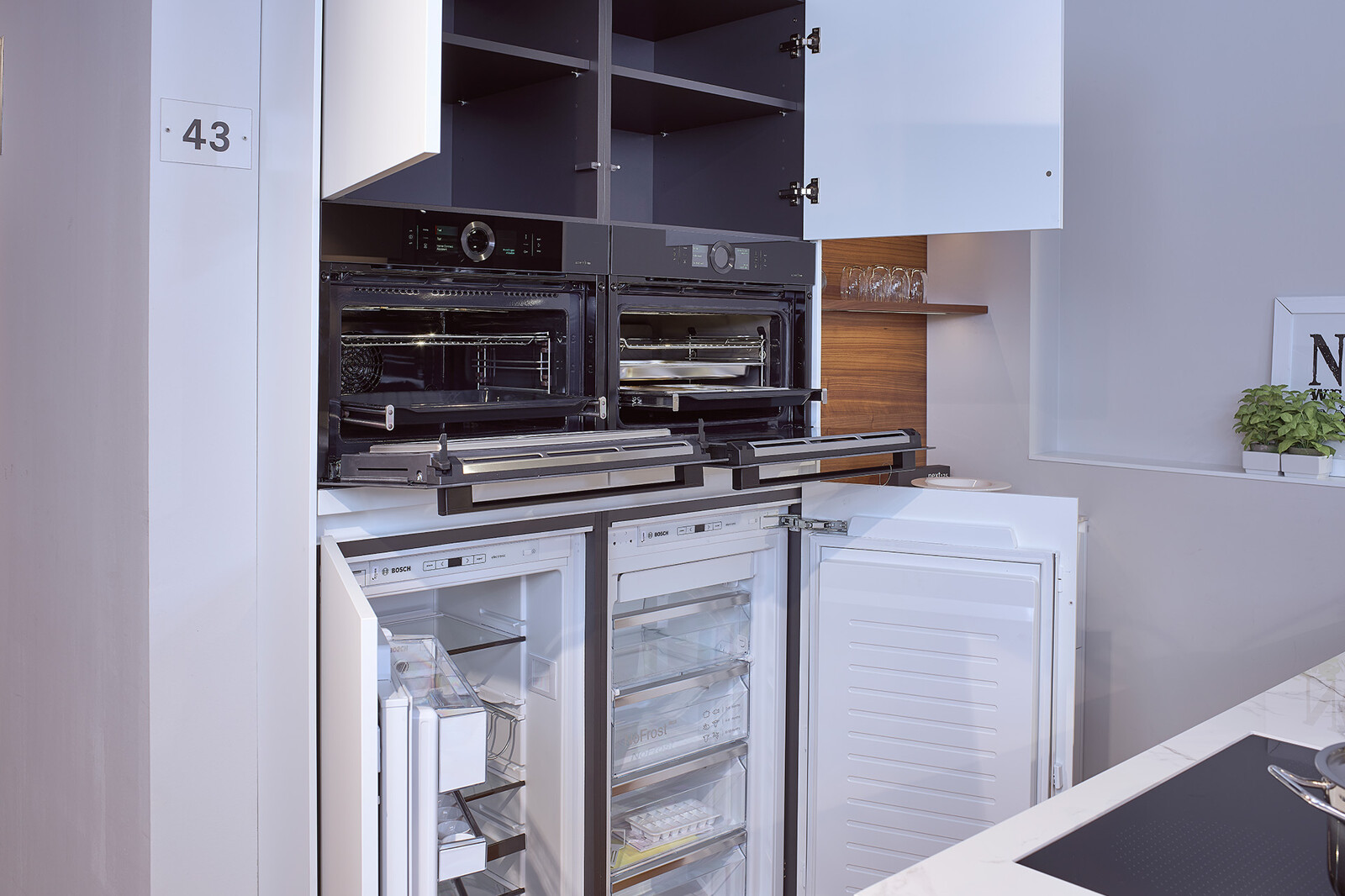 Showroomkeuken next125 - Witte eilandkeuken in fenix met notenhout incl bosch inbouwapparatuur