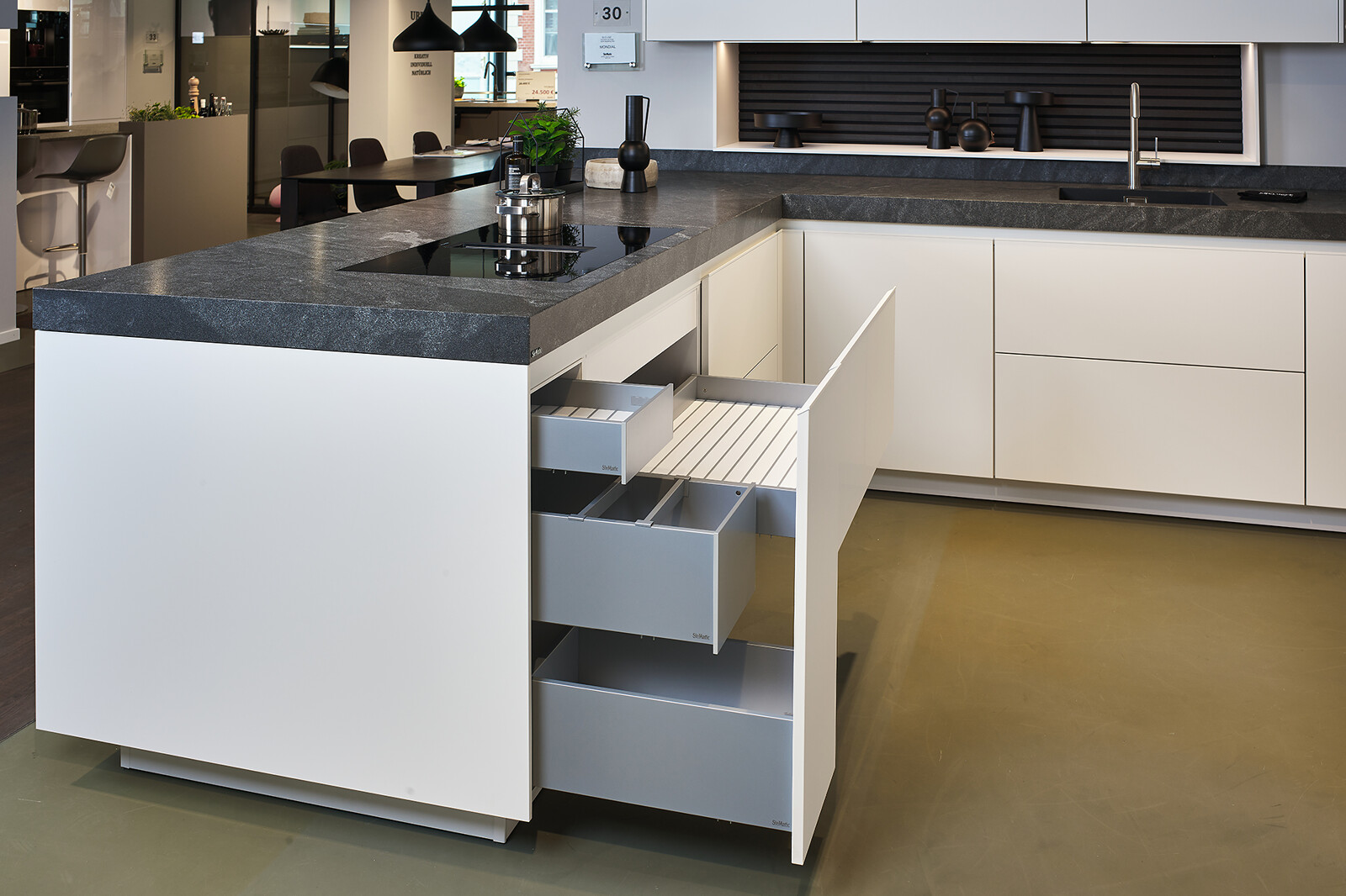 Showroomkeuken: SieMatic Mondial in lotuswit met schiereiland en lades met binnenlades