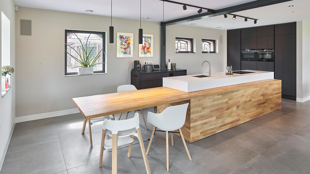 Bijzondere SieMatic S2 Eilandkeuken met eiken maatwerk elementen, zoals de ombouw en tafel met glazen voet en de fronten van de hoge kasten en koffiecorner.