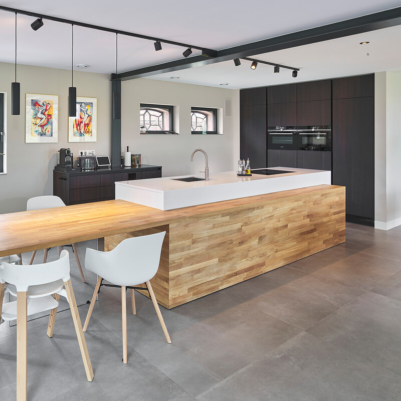 Bijzondere SieMatic S2 Eilandkeuken met eiken maatwerk elementen, zoals de ombouw en tafel met glazen voet en de fronten van de hoge kasten en koffiecorner.