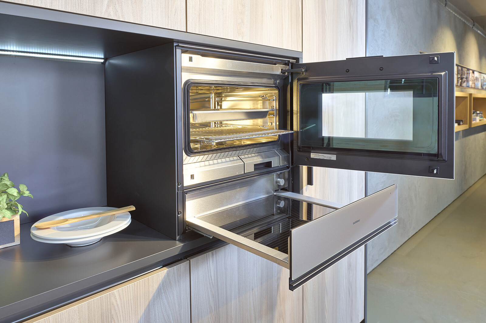 Showroomkeuken: eilandkeuken van Contur met houten kastenwand en Neff apparatuur