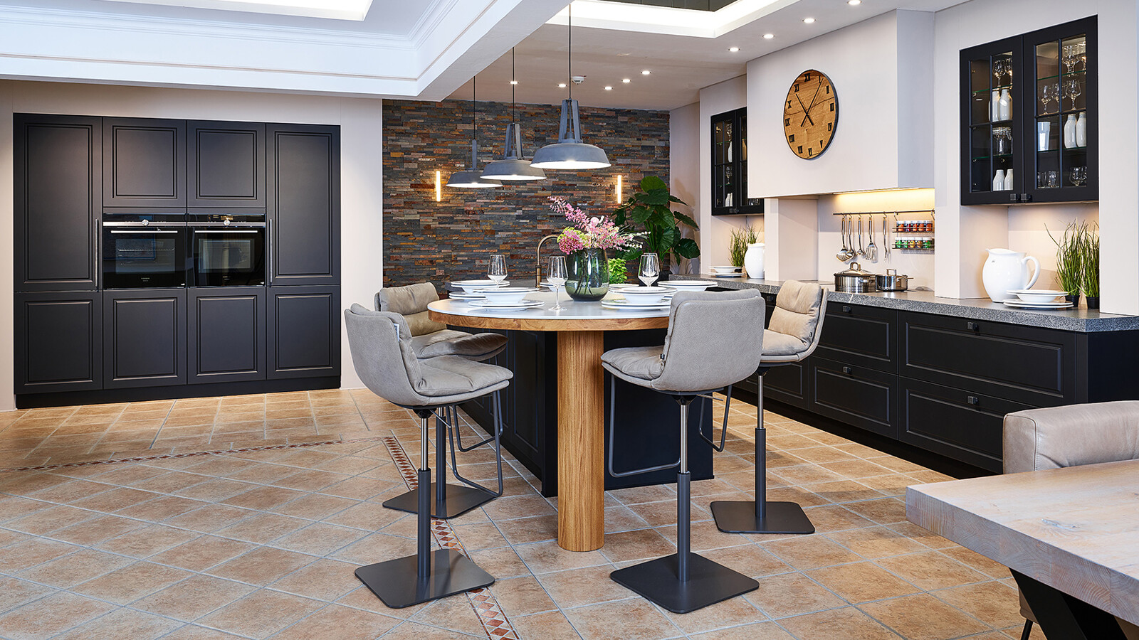 Zwarte landelijke keuken met granieten aanrechtblad en ronde bar, te zien bij Ekelhoff Keukens in Nordhorn