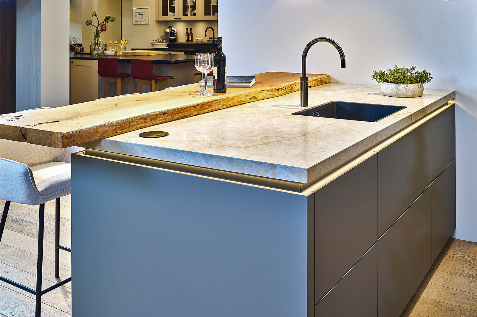 Showroomkeuken Ballerina: taupe eilandkeuken met glanzend keramiek blad en verlichte greeplijst