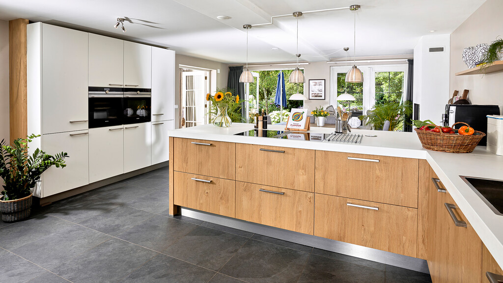 Große Contur-Küche von Schüller Küchen in Mattweiß und heller Eiche, bestehend aus Rückwand mit Hochschränken und Küchenzeile mit Halbinsel. Küche skandinavisch.