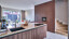 Keuken van Contur met notenhouten fronten, composiet keukenblad en bronskleurige Quooker