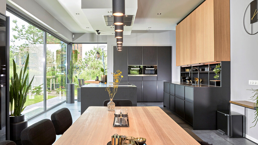 Italiaanse designkeuken - Grote woonkeuken met eettafel, kookeiland en achterwanden in antraciet en licht eiken.