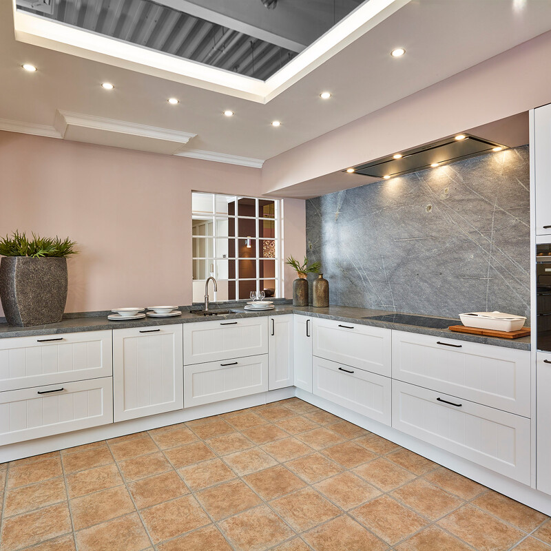 Landhaus-Eckküche mit Arbeitsplatte und Rückwand aus Sky Blue Granit - Ekelhoff Kuechen in Nordhorn