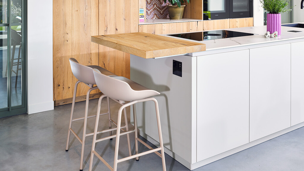 Maatwerkkeuken in balken-eikenhout met keukeneiland van Ballerina. De barplaat biedt plaats aan twee barkrukken.