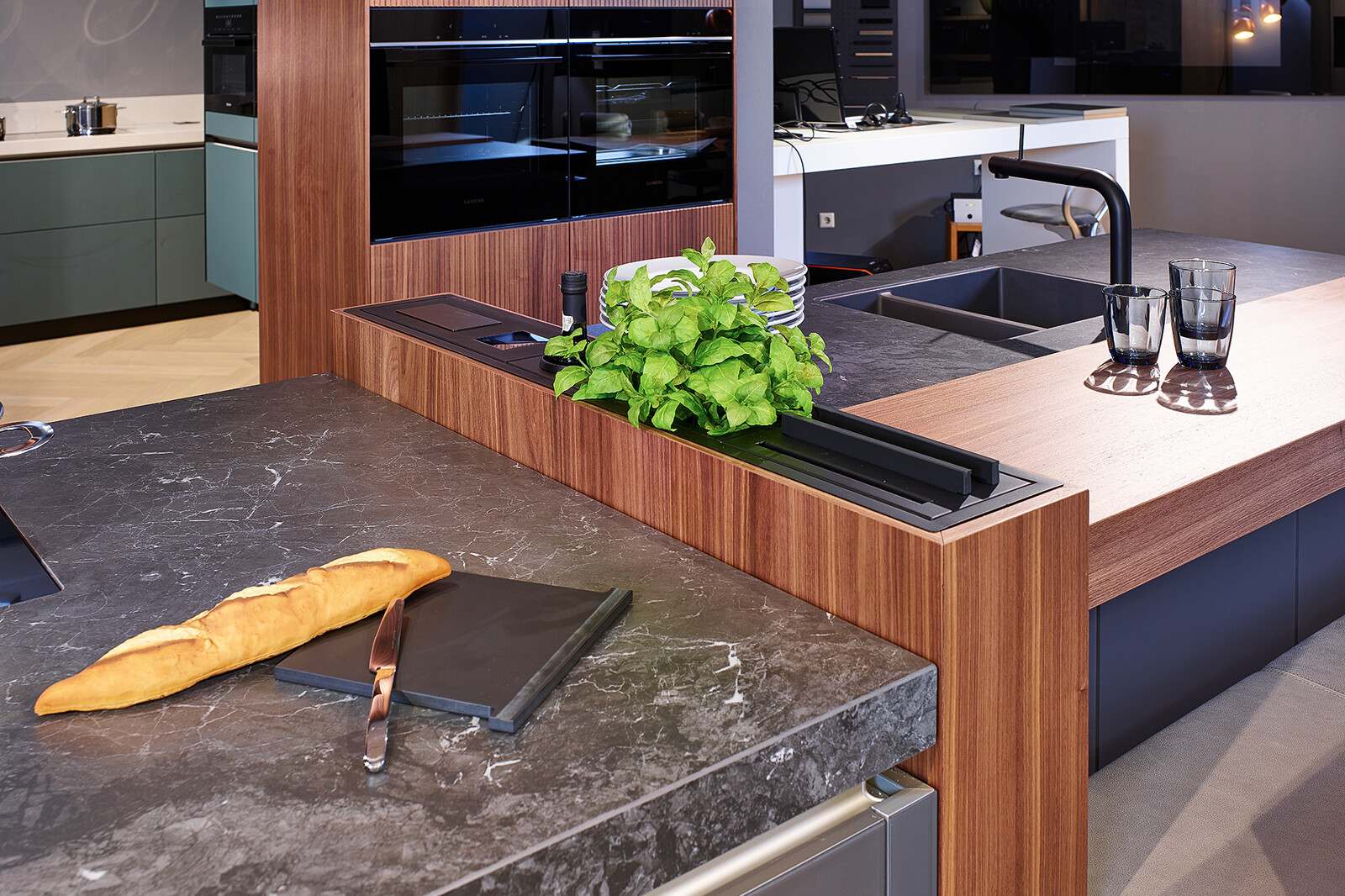 Showroomkeuken: next125 design eilandkeuken met bar in notenhout en matglas met maatwerk element uit eigen werkplaats
