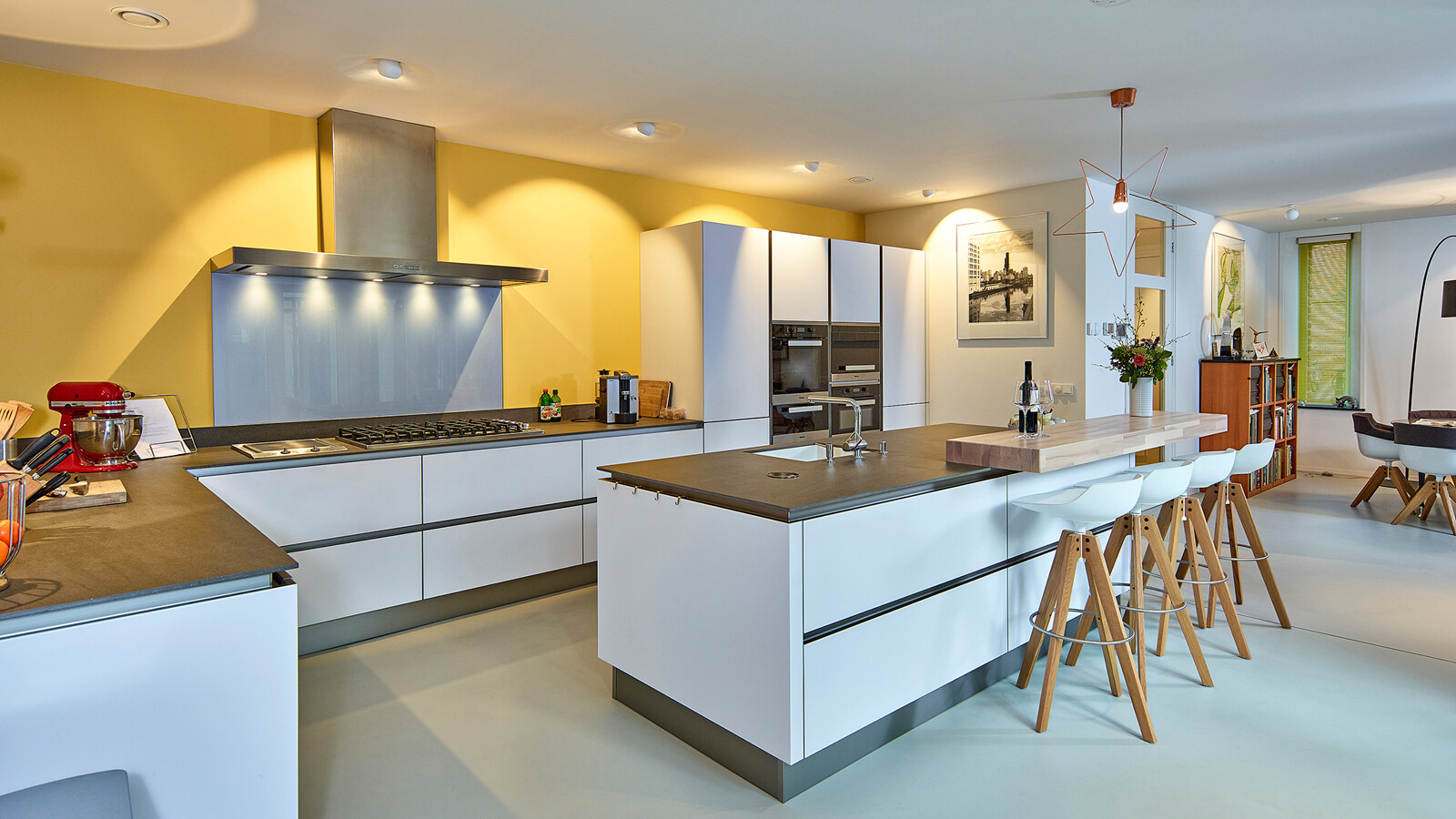 Diese gemütliche offene Küche von next125 hat Fronten aus weißem satiniertem Glas und eine großzügige Spülinsel mit Holzbarplatte