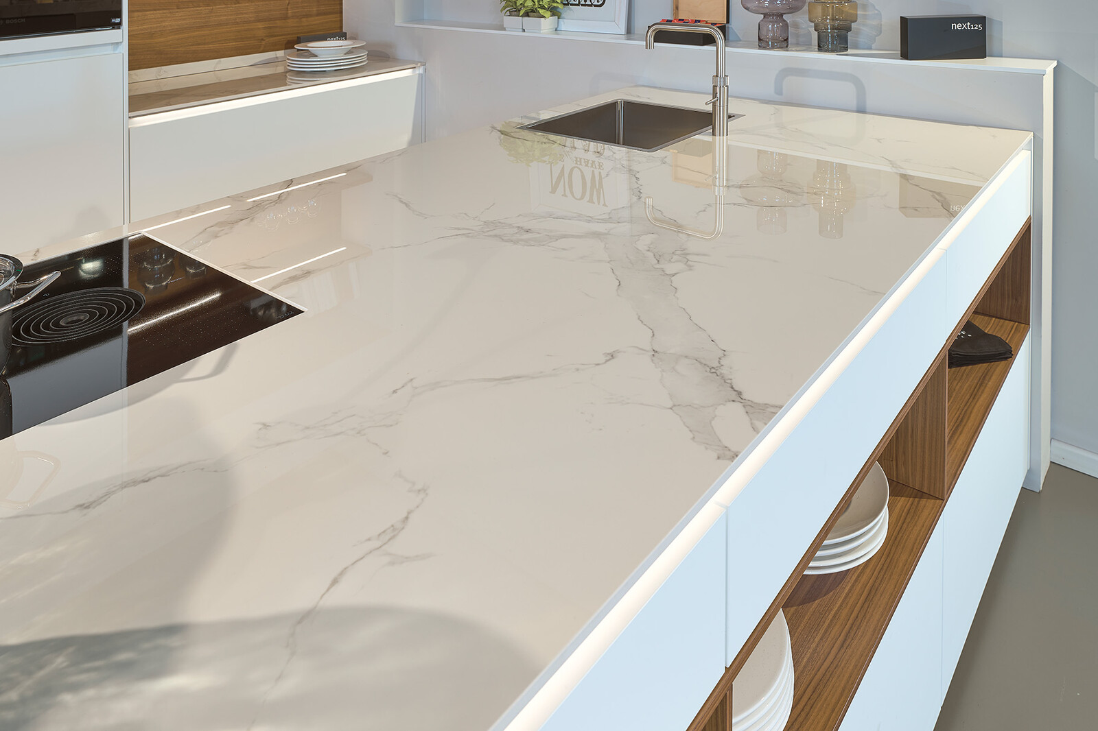 Showroomkeuken next125 - Witte eilandkeuken in fenix met notenhout en marmerlook keramiek keukenblad
