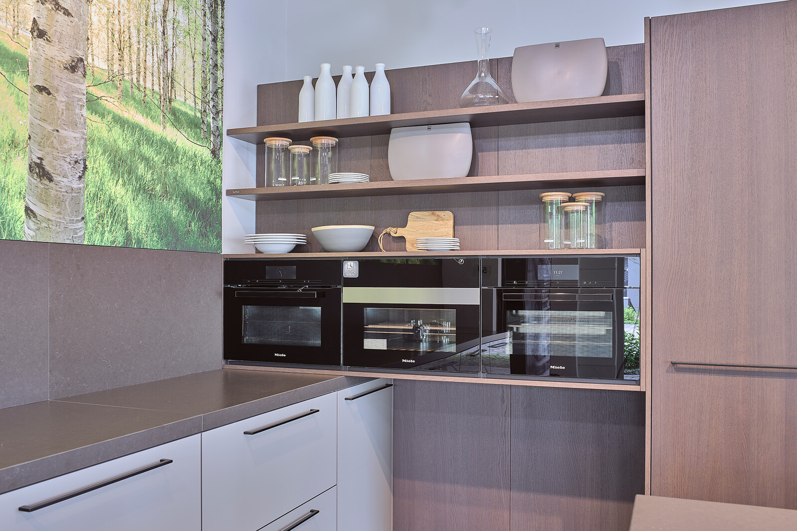 Showroomkeuken: SieMatic designkeuken in L-vorm met keukeneiland en Hazelbrown eikenfineer kastenwand