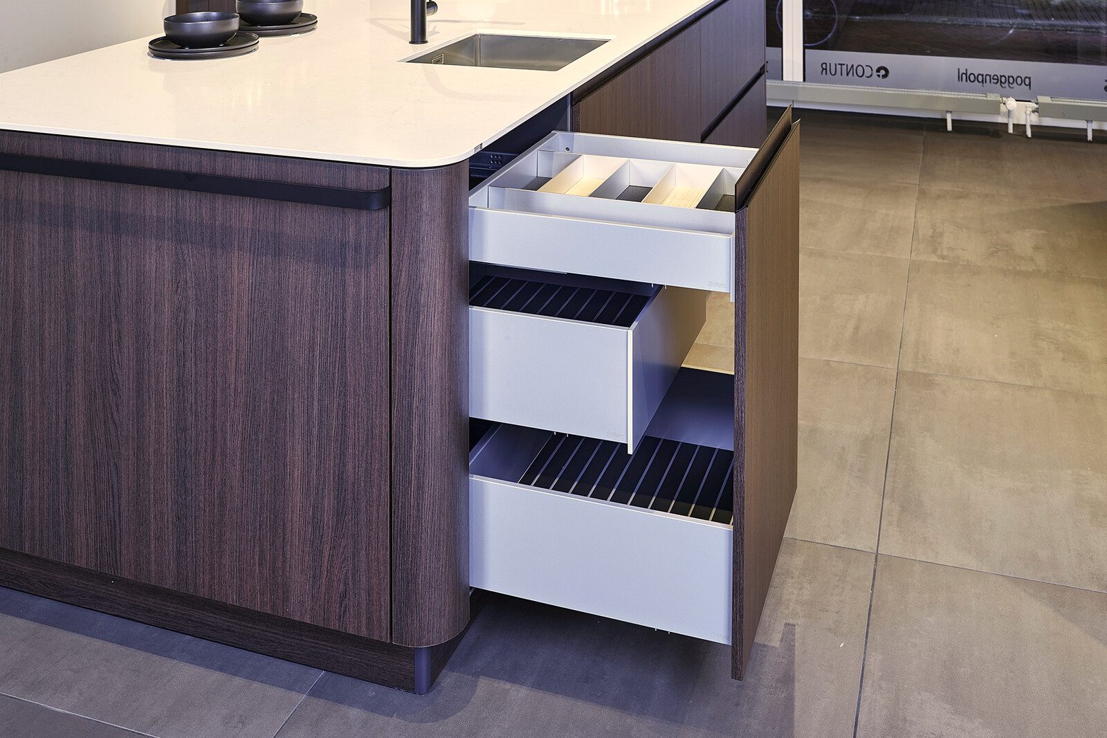 Showroomkeuken: SieMatic designkeuken met afgeronde hoeken en praktische lades