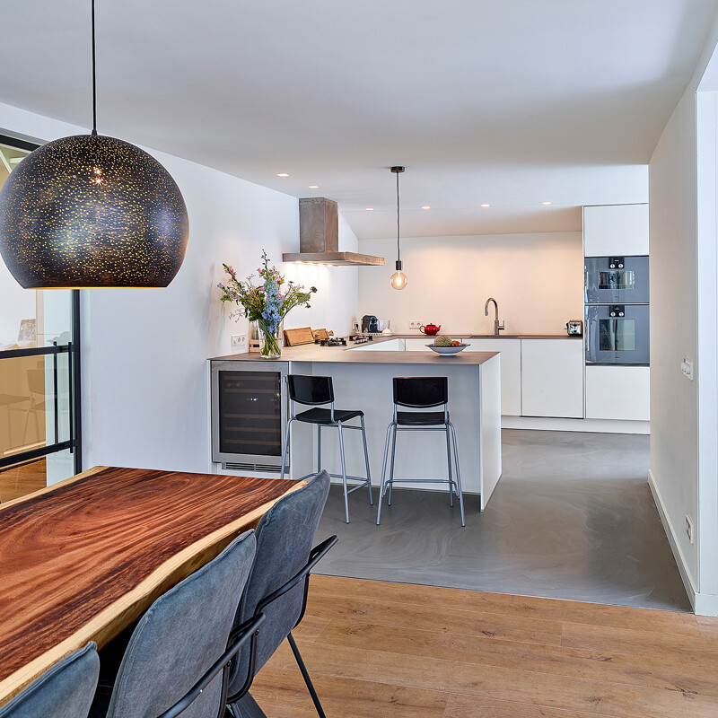 Greeploze u-keuken in magnolia met rvs keukenblad, zitgelegenheid en Gaggenau apparatuur van Ekelhoff Keukens. Lees de keukenreview  met foto's. Keuken geinstalleerd in Het Gooi