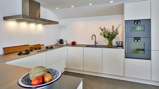 Grifflose U-Küche in Magnolie mit Edelstahl-Arbeitsplatte und Gaggenau-Geräten von Ekelhoff Küchen. Lesen Sie den Küchenbericht mit Fotos.