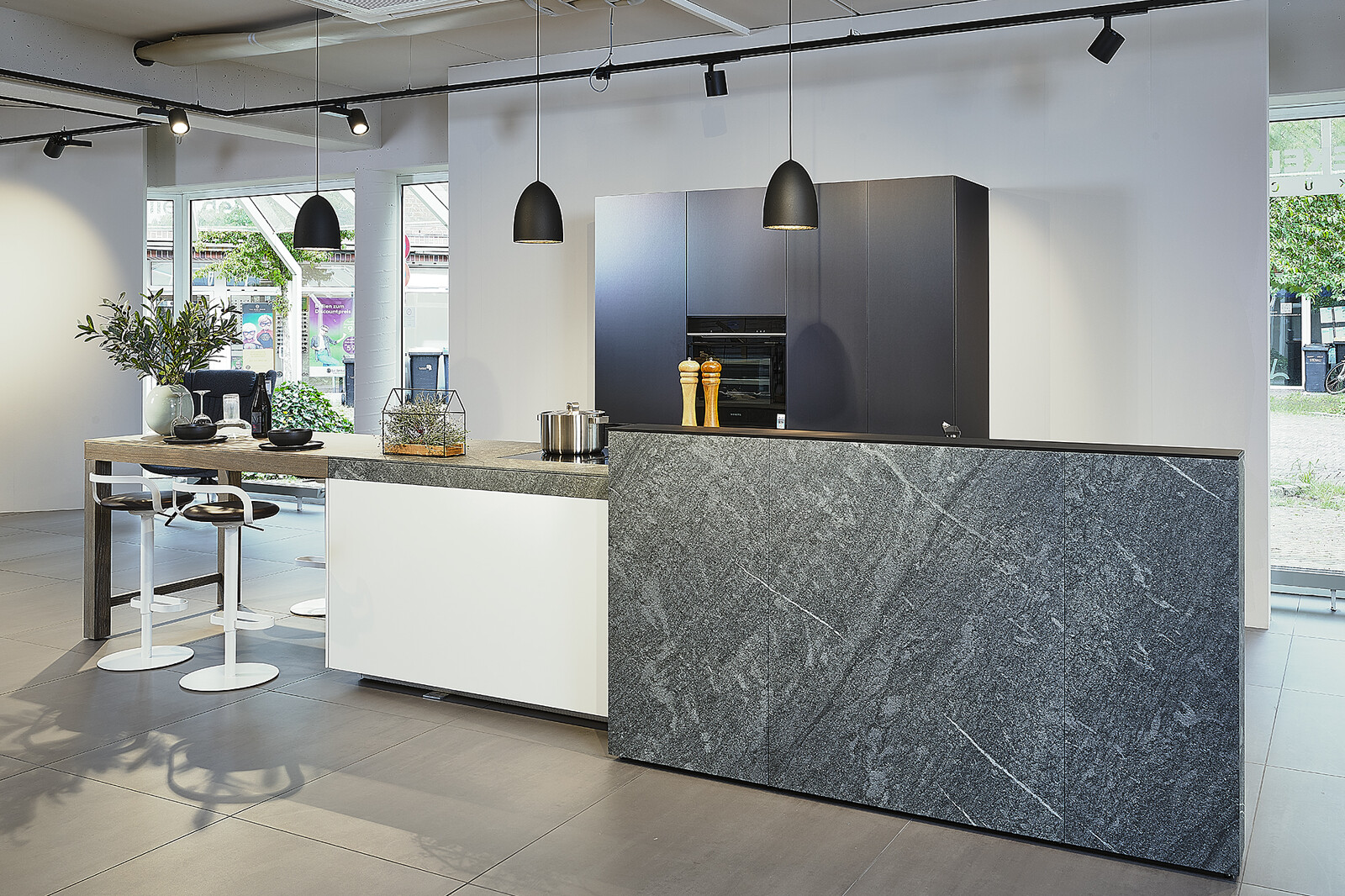 Showroomkeuken: Valcucine designkeuken met kookeiland, granieten keukenblad en bartafel