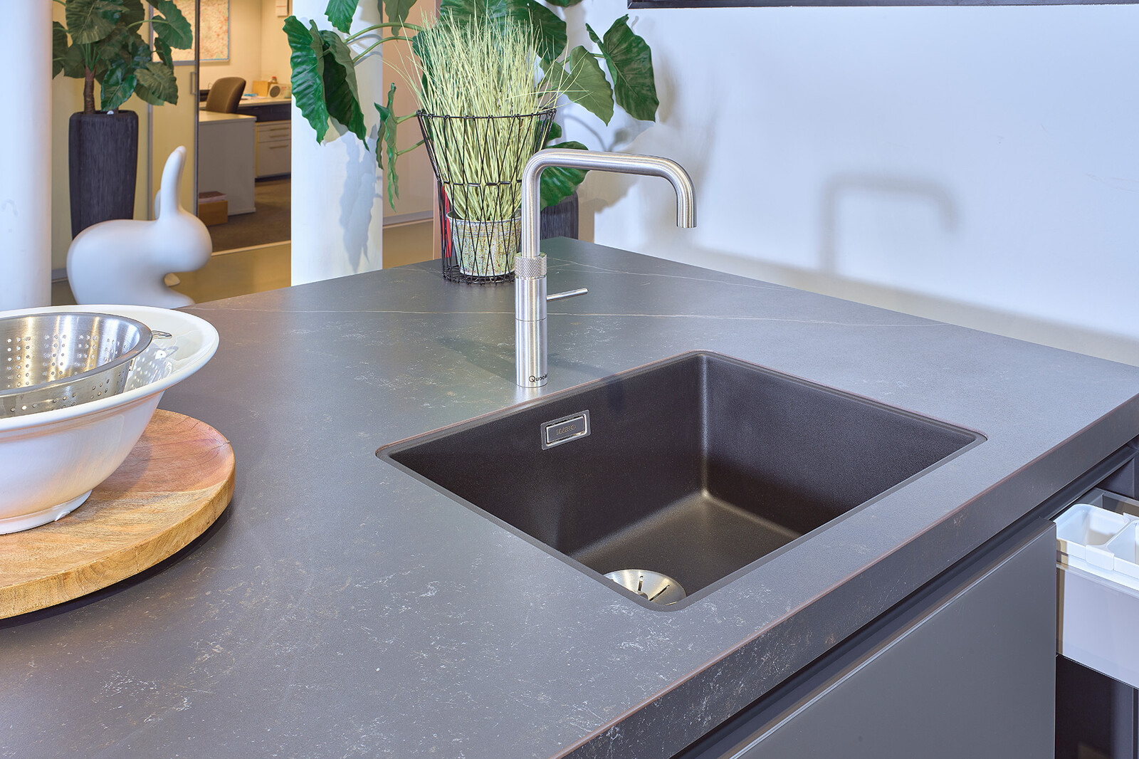 Showroomkeuken: eilandkeuken met zwart keukeneiland, dekton blad en zwarte spoelbak
