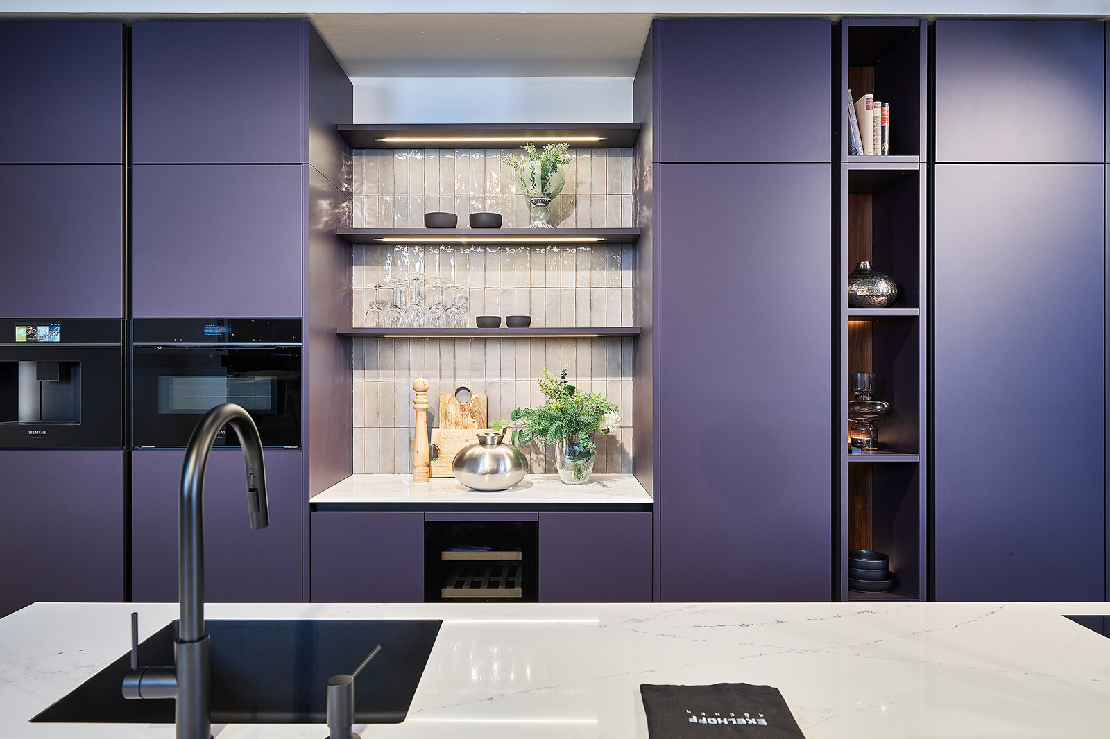 Designkeuken in Aubergine en notenhoutfineer van next125 met wit marmerlook keukenblad