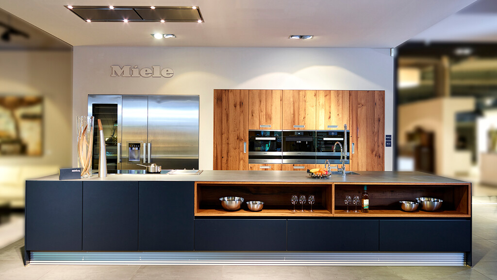 Keuken met lang kook- en spoeleiland in jaguargroen, keuken hoge kasten in oud-eikenfineer.