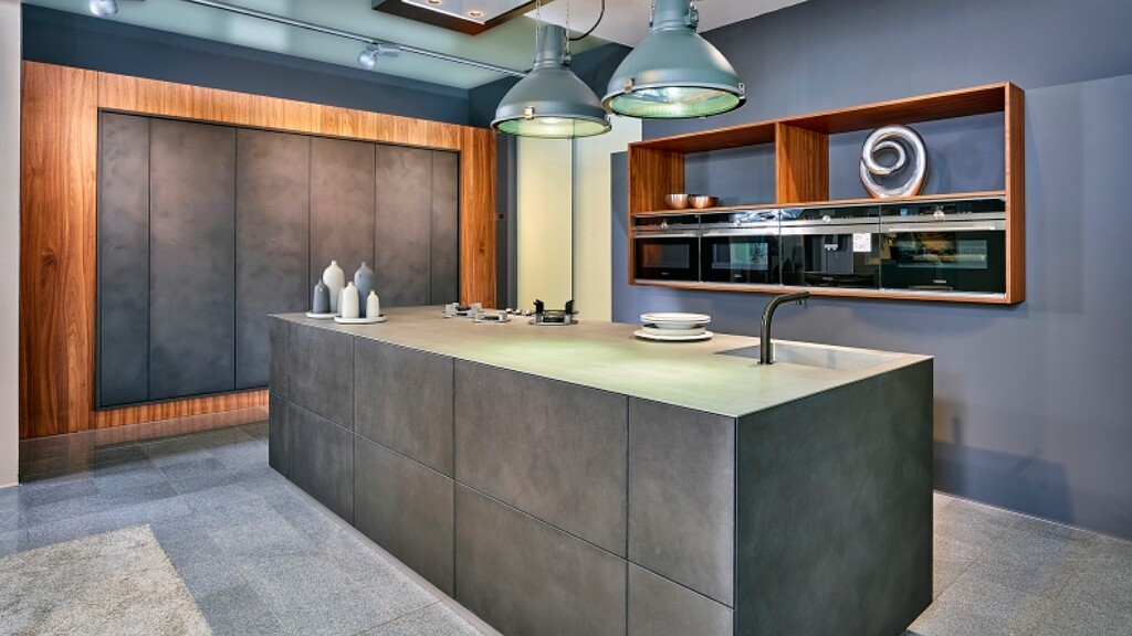 Grifflose Inselküche in Betonlook und Nussbaum