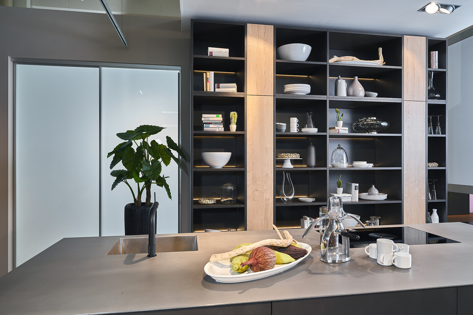 Showroomkeuken: Industriële eilandkeuken van Contur met rvs aanrechtblad, staallook fronten en open wandkast