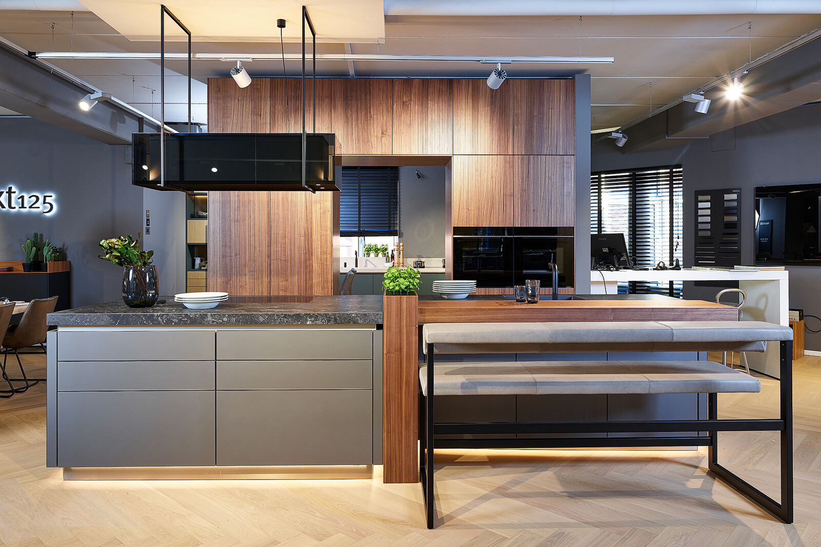 Showroomkeuken: next125 designkeuken met kookeiland in notenhout lamellenfronten en matglas fronten