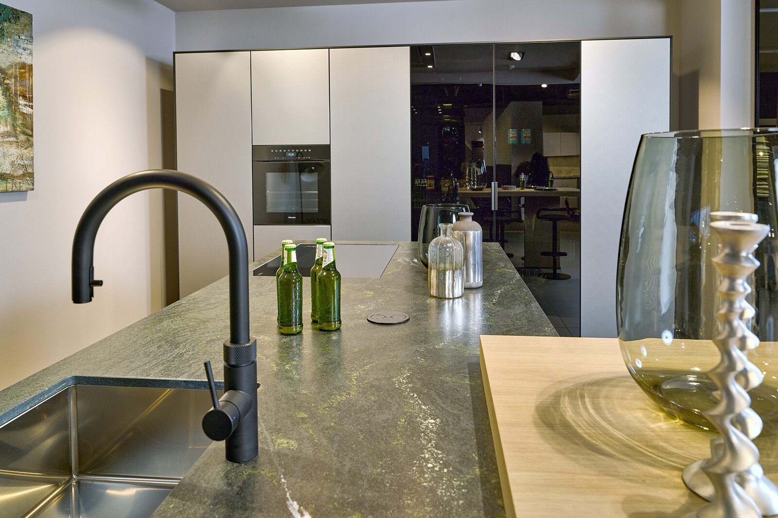 Showroomkeuken: next125 designkeuken met groen granieten keukenblad en inox metallic fronten