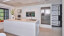 Greeploze eilandkeuken van next125 in hoogglanslak met wit keramiek keukenblad. Lees de keukenreview en bekijk de foto's.