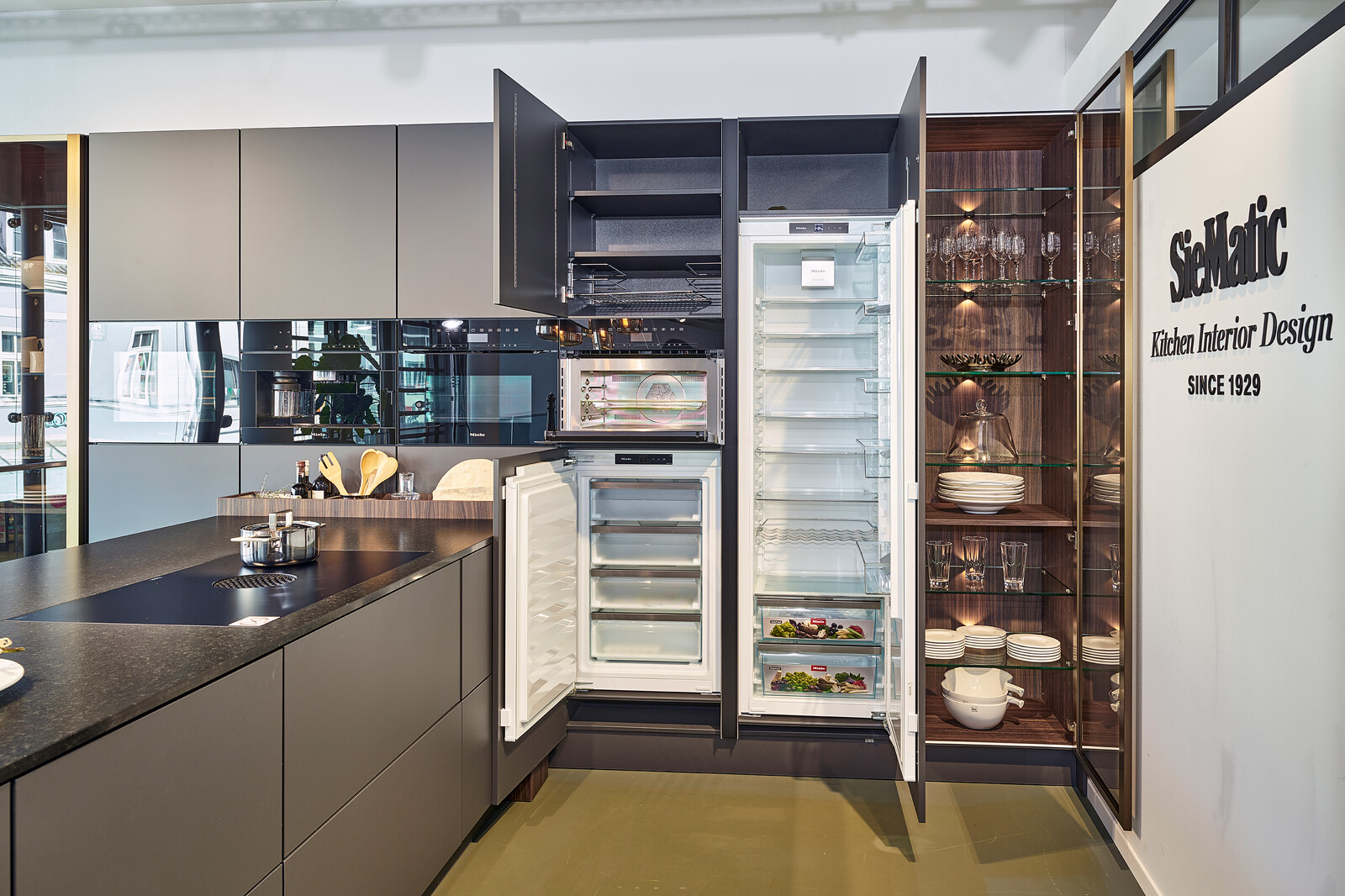 Showroomkeuken: SieMatic S2: grafietgrijze keuken met vitrinekasten en Miele apparatuur