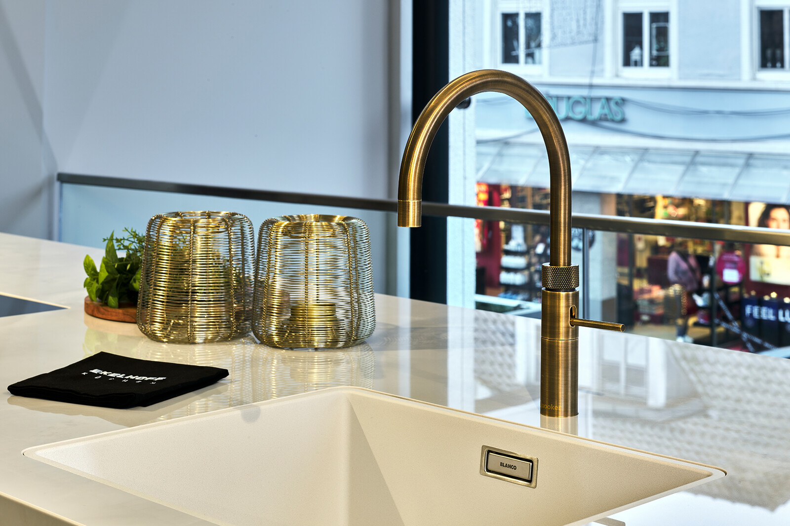Showroomkeuken: SieMatic SLX-LS eilandkeuken Umbra met dekton blad en messing Quooker kraan