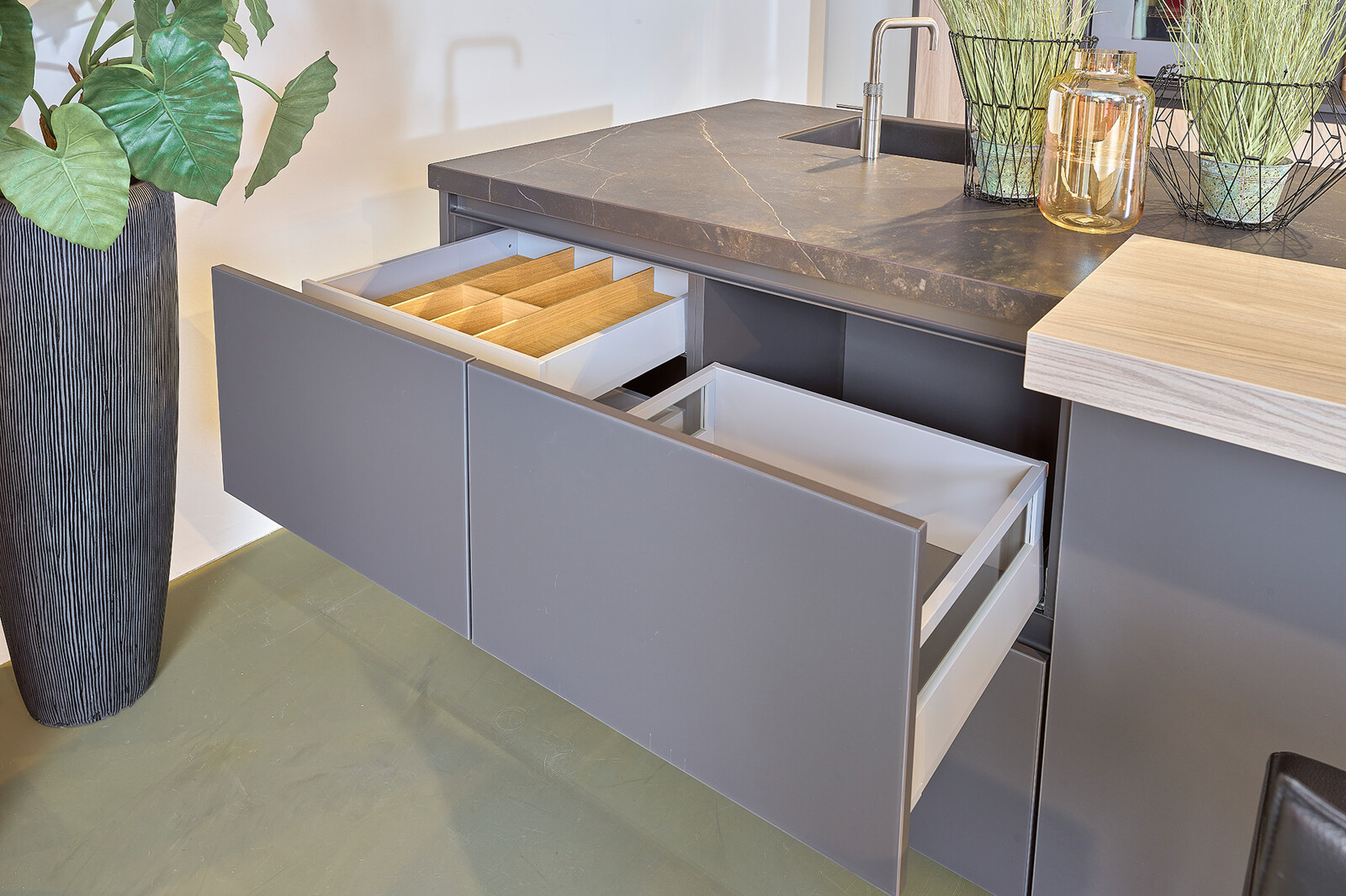 Showroomkeuken: zwarte eilandkeuken met Dekton blad en veel praktische lades - Ekelhoff Keukens