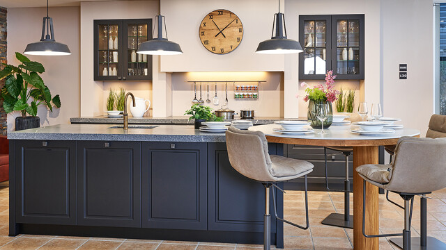 Zwarte landelijke keuken van Contur met keukeneiland vitrine bovenkasten en ronde bartafel-Ekelhoff Keukens