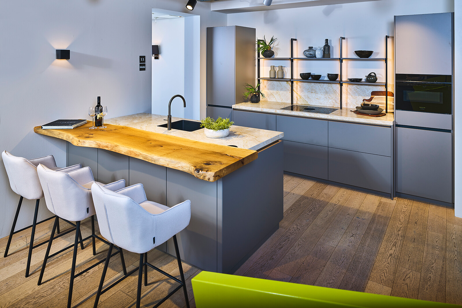 Showroomkeuken Ballerina: taupe eilandkeuken met houten bar en industrieel rek -  Ekelhoff
