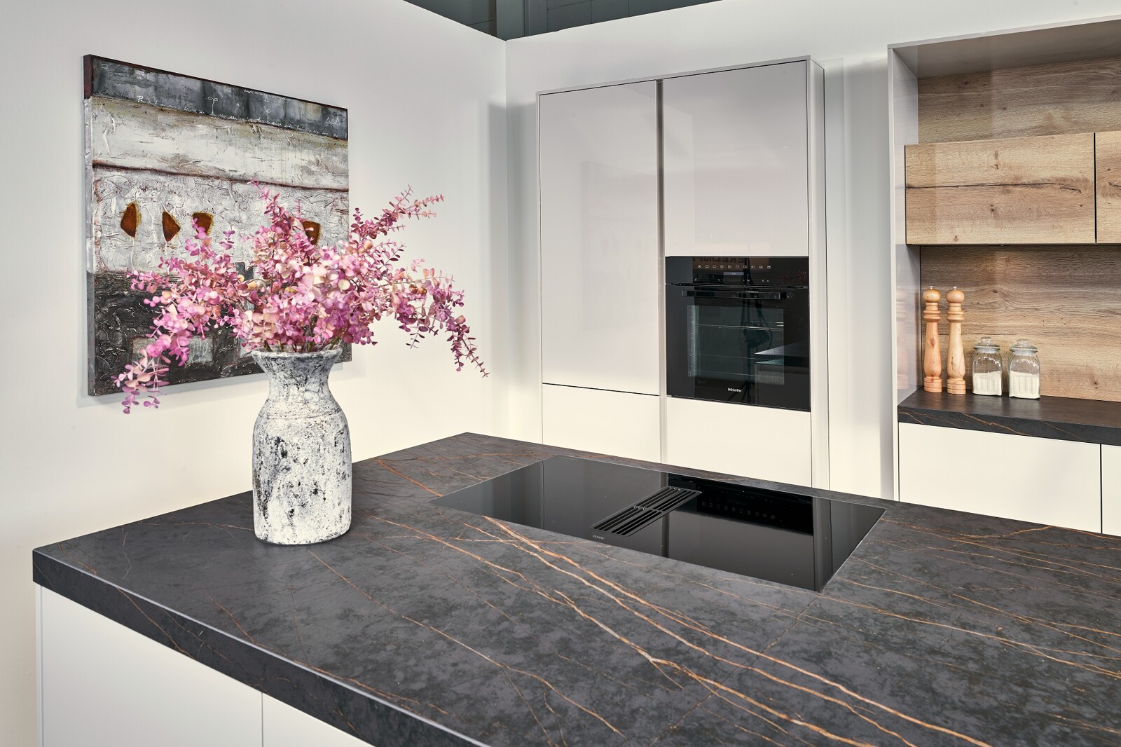 Showroomkeuken: eilandkeuken in hoogglans schelpwit met keramiek Dekton blad en houten details