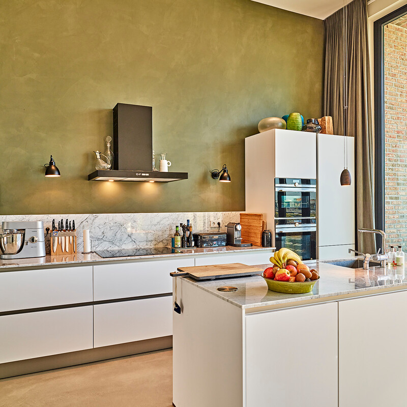 Grifflose weiße Küche von Contur mit Spülinsel und Arbeitsplatte und Rückwand aus Marmor. Realisiert in Amsterdam von Ekelhoff Küchen, Deutschland.