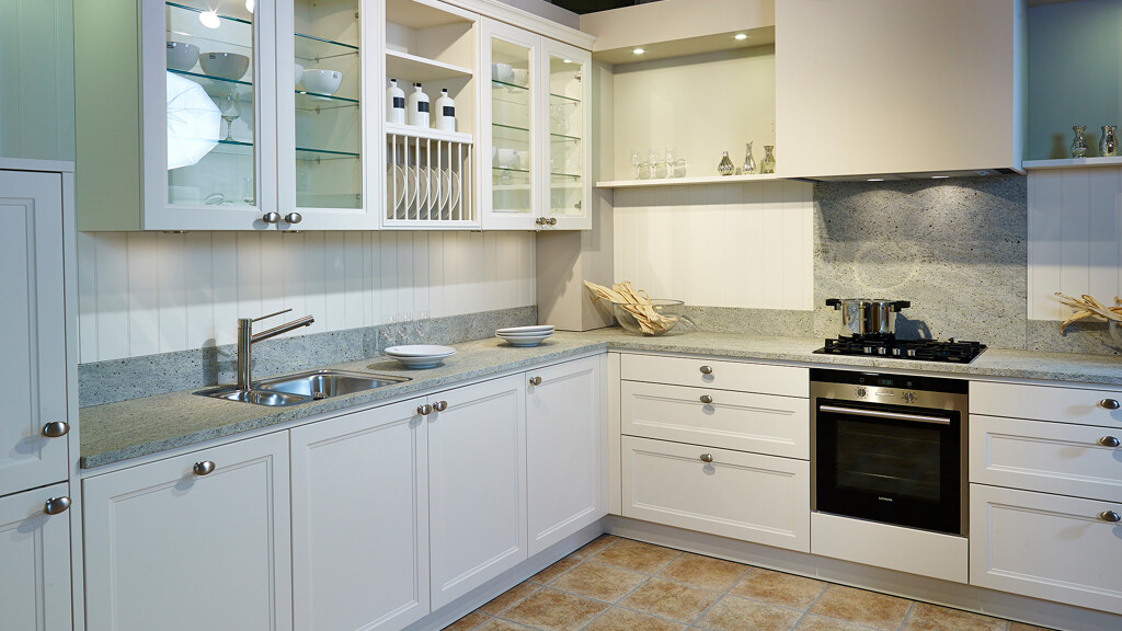 Witte landelijke keuken van Contur - hoekkeuken met vitrinekasten - showroomkeuken bij Ekelhoff Keukens