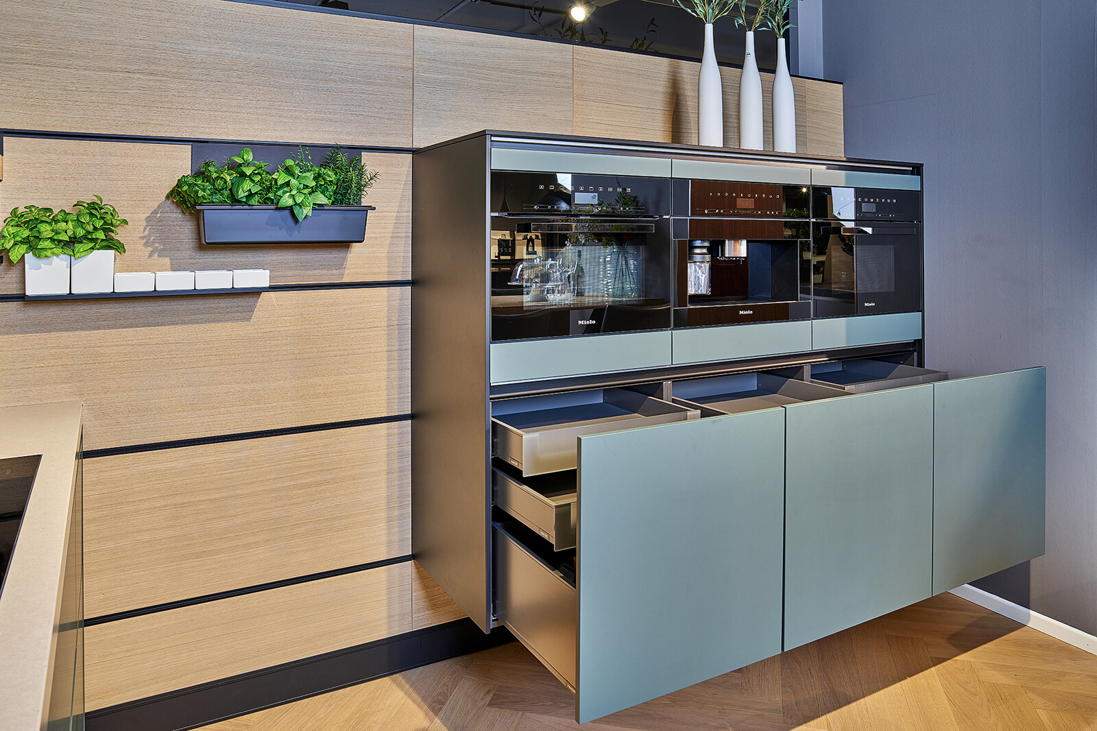 Showroomkeuken: Groene next125 designkeuken met cube achterwand en miele apparatuur