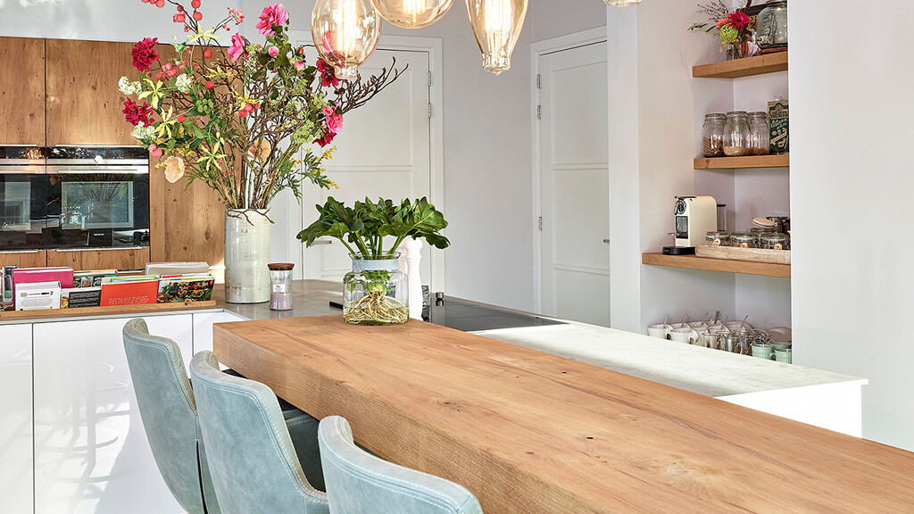 Een keuken met L-vormig eiland en koffie nis.